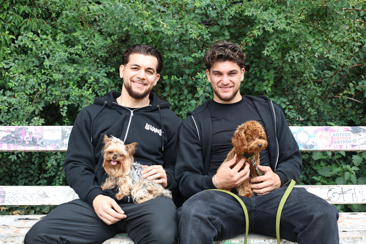 Erik mit Debby und Georgi mit Levi auf einer Parkbank